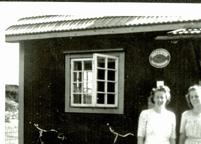 Signe Segerman (Hjelm) framför det lilla postkontoret i Riala (Eneby) som hon förestår. Till höger brorsdottern Ingalill Segerman (Lillan) gift Lindstedt, som var Signes assistent. Signe ansvarade för postkontoret tills det stängdes 1968. Bilden tillhandahållen av Ingegärd Blomdin, systerdotter till Signe Hjelm.